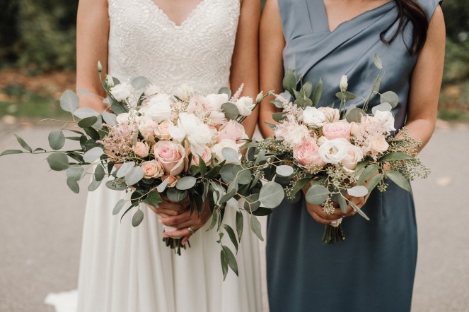 Bride and bridesmaid holding bouquets.